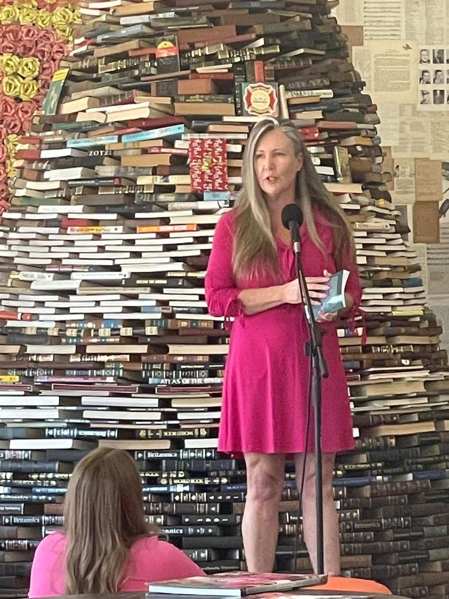 Sharon Fekete reading at a book talk in front of a wall of books